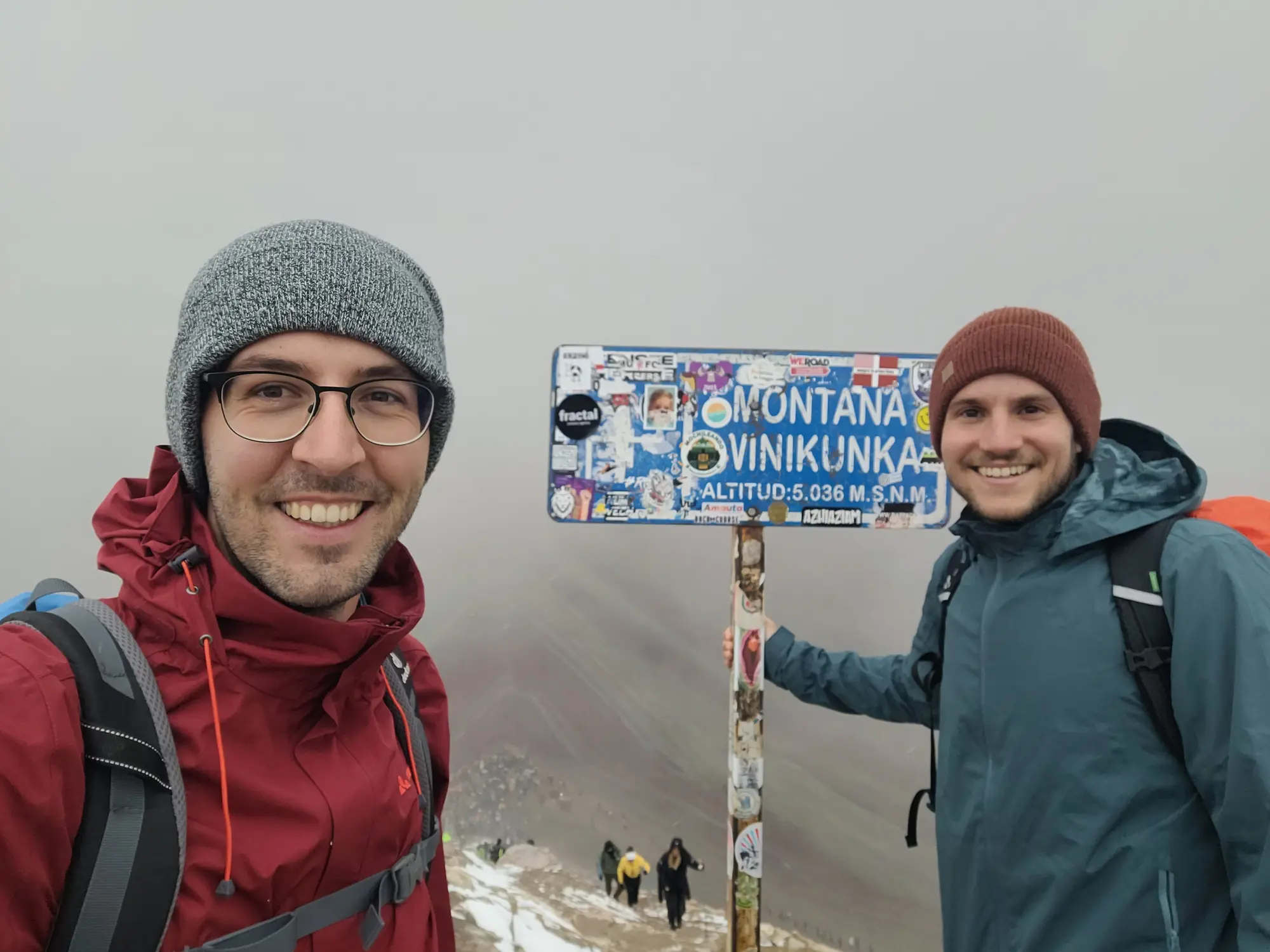 Summit sign at Rainbow Mountain in cloudy weather