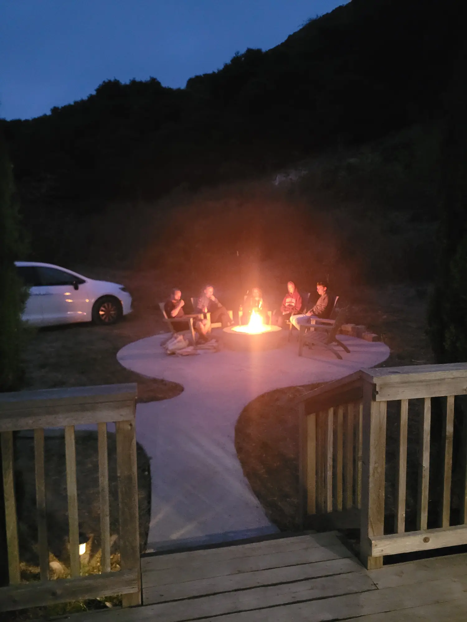 Small group sitting around a campfire at night