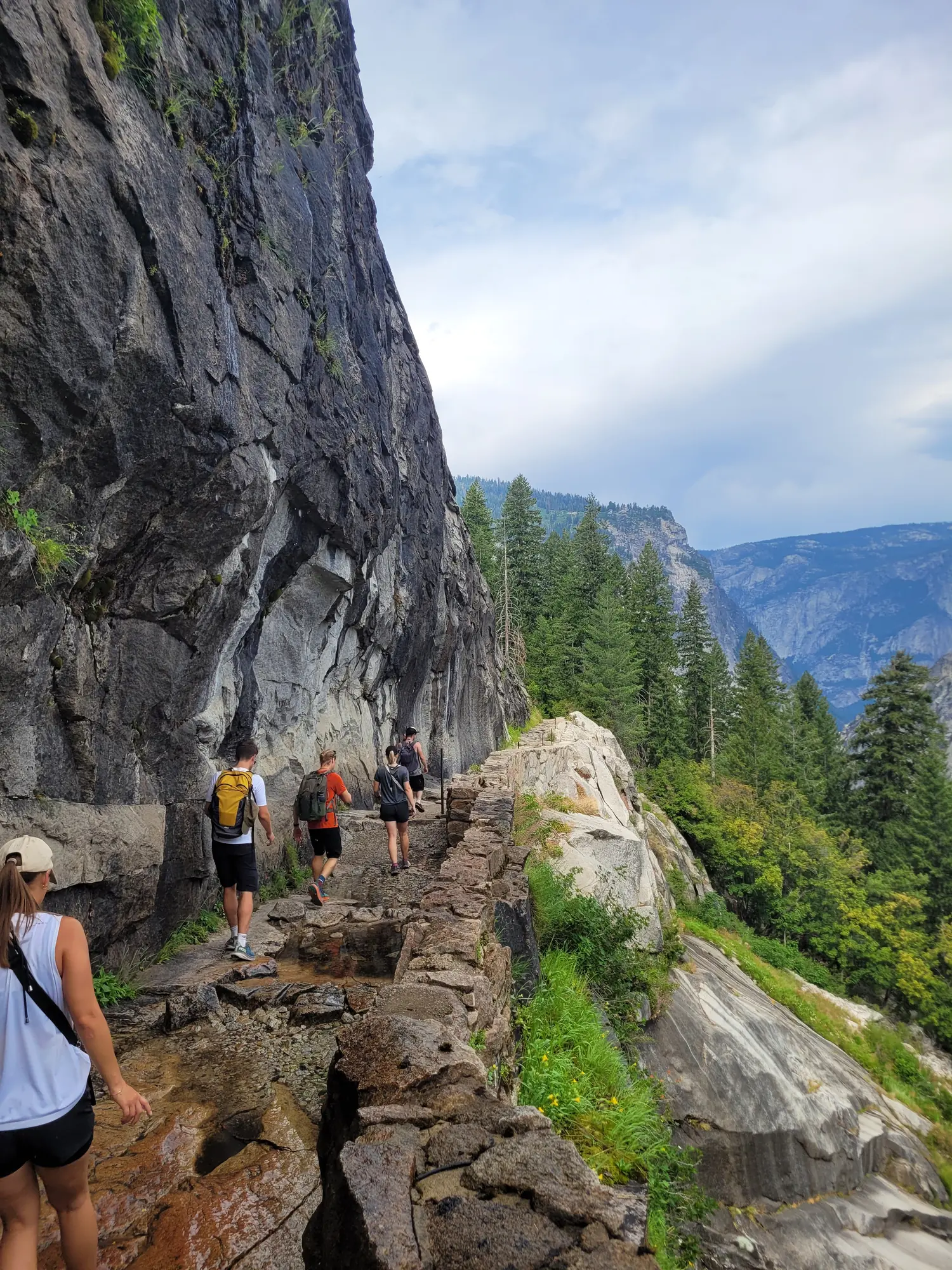 People hiking on a rocky Yosemite waterfall trail